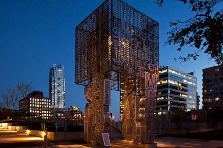 Installation in front of the night sky with tall buildings in the background