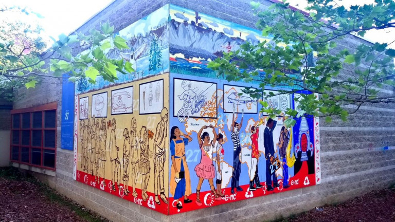 Mural of people walking and dancing on the exterior of a building