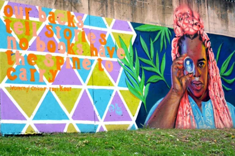 Colourful mural of a person with pink hair