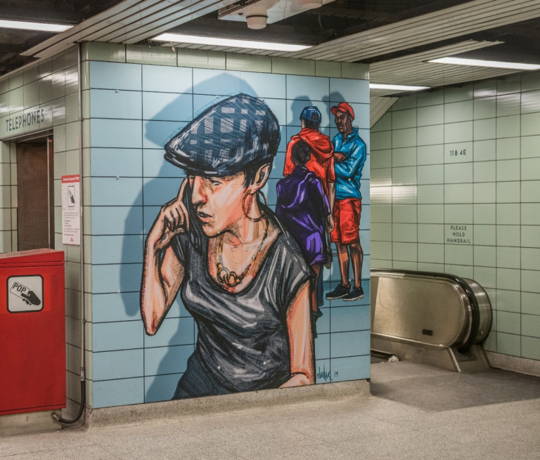 Mural of a woman on a cellphone, located in a TTC station