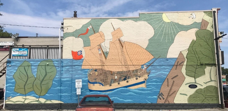 Mural of a ship in the water and cliffs