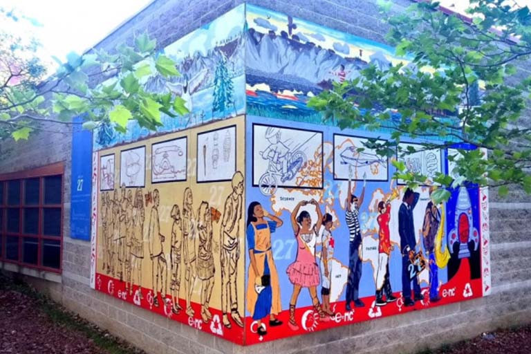 Mural of people walking and dancing on the exterior of a building