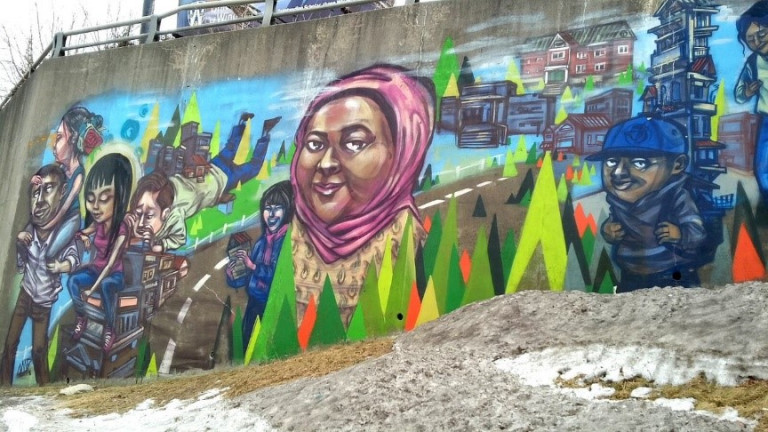 Mural of multiple people in primarily blue tones