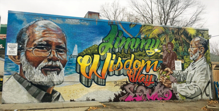 Mural with large image of a man reading Jimmy Wisdom Way
