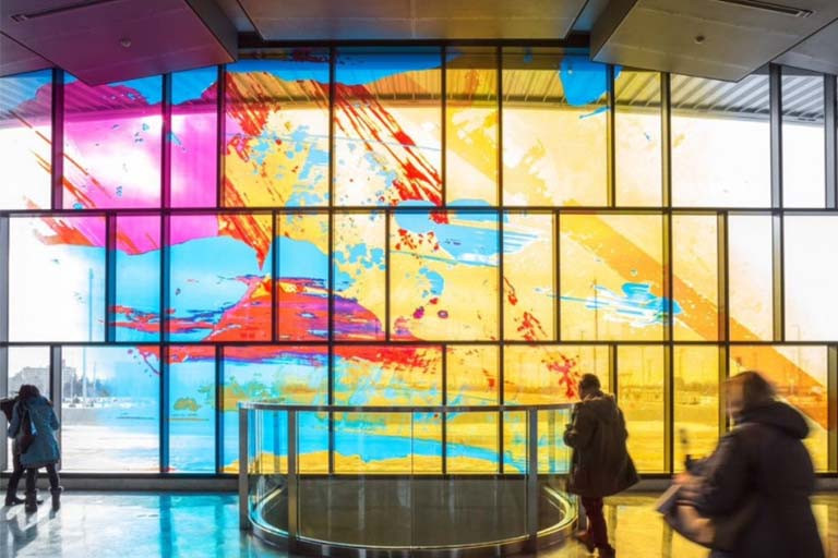 Colourful abstract mural on windows in a TTC station