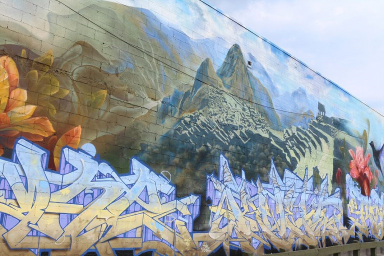 Mural with a mix of landscape and graffiti words