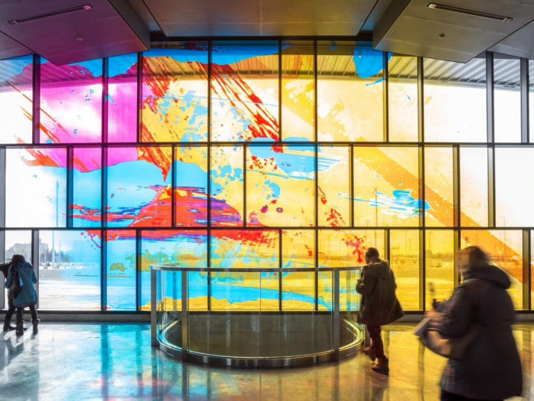 Colourful abstract mural on windows in a TTC station
