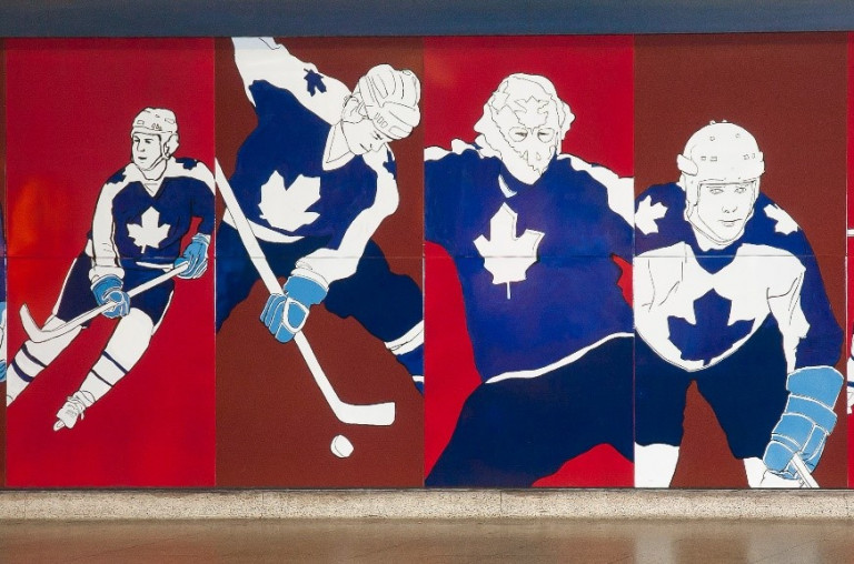 Mural of maple leaf players on a red background, located in a TTC station