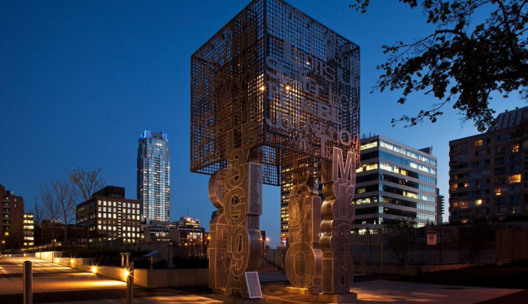Installation in front of the night sky with tall buildings in the background